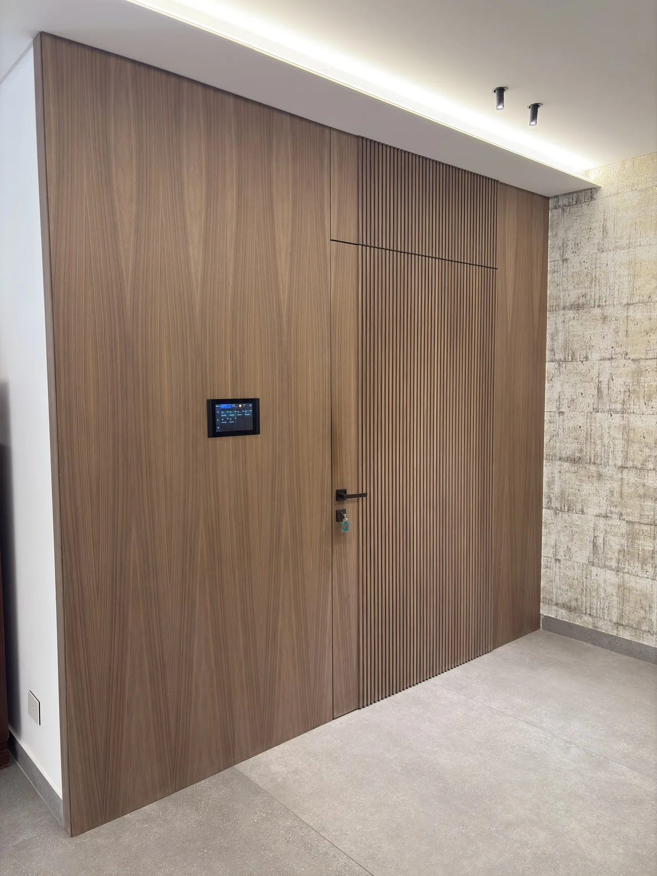 Entrance wall — walnut cladding and flush automation panel