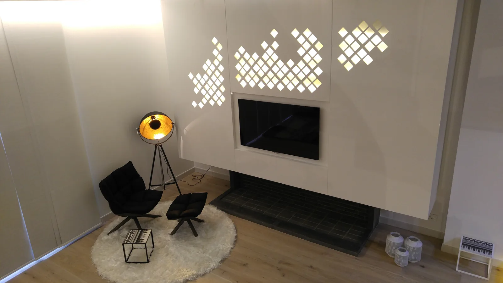 Backlit perforated panel above the fireplace