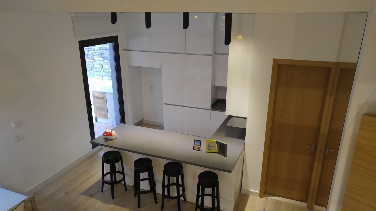 Chalet kitchen — handleless gloss units and a solid oak door